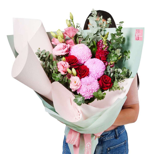 The Look of Love Bouquet with pink chrysanthemums roses and eucalyptus wrapped in soft pastel paper for romantic occasions and same day flower delivery