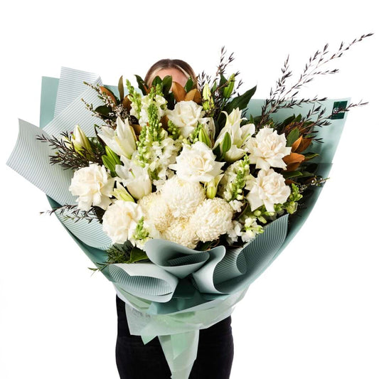 Pure Indulgence Bouquet of white chrysanthemums lilies carnations and roses with fresh greenery wrapped in elegant paper for same-day delivery flowers