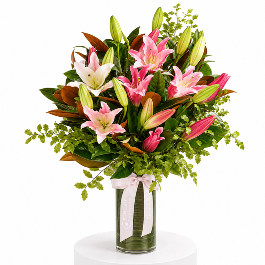 Pink Lily Queen Vase featuring fresh pink lilies and lush green foliage arranged in a glass vase for birthday flowers and same-day delivery flowers
